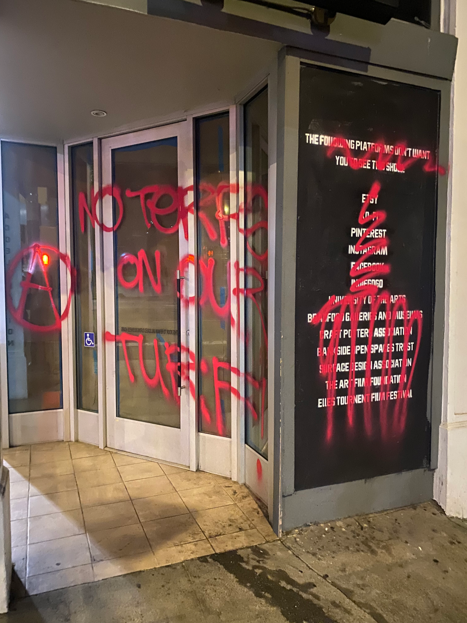 the entrance of a building covered in grafitti: "NO TERFS ON OUR TURF!"